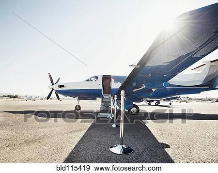 Stock Photo - Velvet rope by airplane on runway. Fotosearch