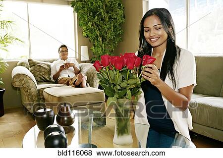 Stock Photo - Woman arranging flowers in vase. Fotosearch