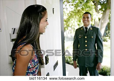 Picture - Woman greeting soldier boyfriend at door. Fotosearch