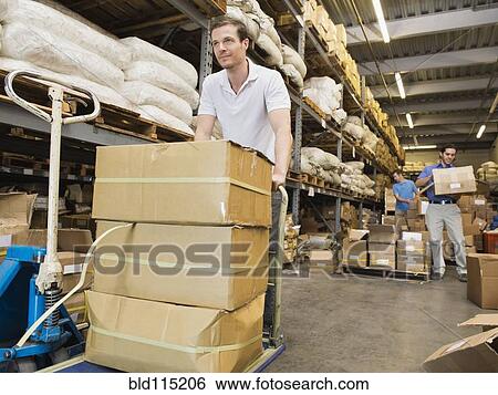 Stock Photograph - Worker stacking boxes in textile factory. Fotosearch