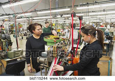 Picture - Workers operating machinery in textile factory. Fotosearch