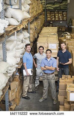 Stock Image - Workers smiling in textile factory. Fotosearch
