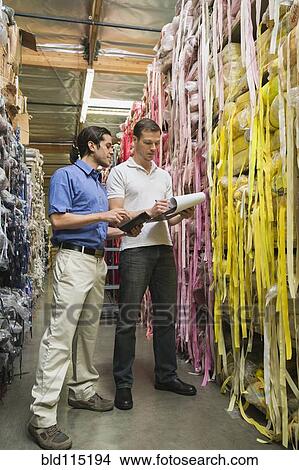 Picture - Workers talking in textile factory. Fotosearch