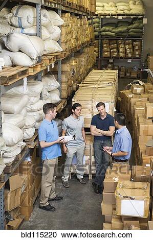Stock Image - Workers talking in textile factory. Fotosearch