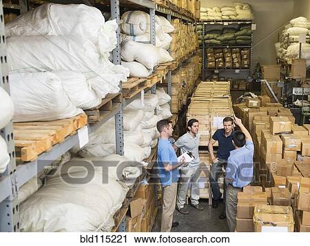Stock Image - Workers talking in textile factory. Fotosearch