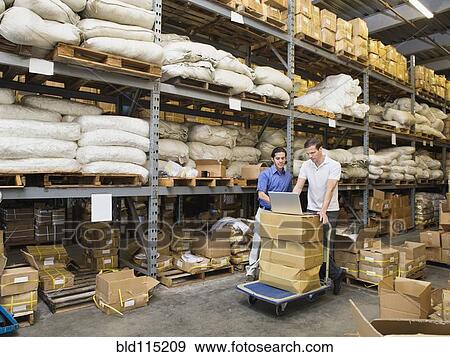 Stock Photo - Workers using laptop in textile factory. Fotosearch