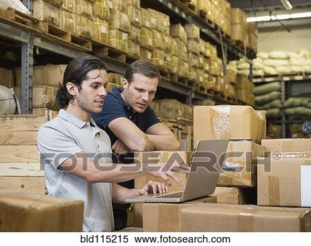 Stock Photography - Workers using laptop in textile factory. Fotosearch