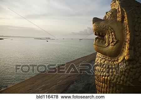 A carved lion head statue in profile overlooking the Tonle Sap River at dawn View Large Photo Image Stock Photo - A carved lion head statue in profile overlooking the Tonle Sap River at dawn. Fotosearch