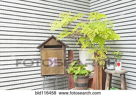 Stock Photo - A corner outside a house, with a mailbox and green plants. Fotosearch
