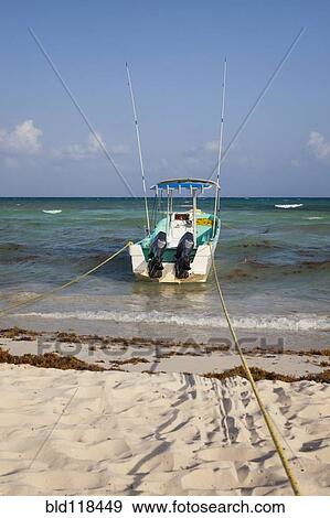 A fishing boat anchored at the edge of the water View Large Photo Image Stock Photo - A fishing boat anchored at the edge of the water. Fotosearch