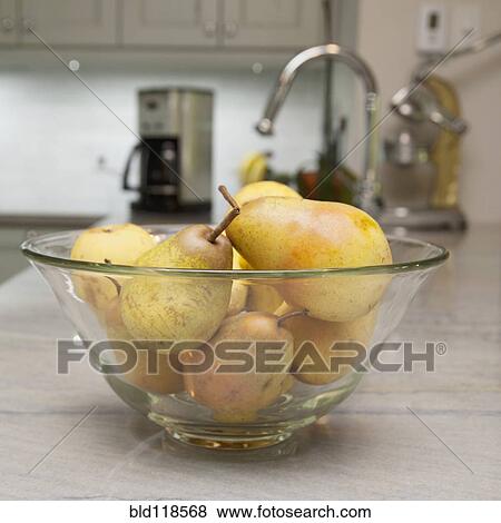 A glass fruit bowl full of pears on a kitchen counter in a modern fitted kitchen View Large Photo Image Stock Photo - A glass fruit bowl full of pears on a kitchen counter in a modern fitted kitchen. Fotosearch