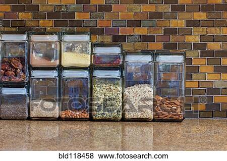 A kitchen in a home with a tiled wall, and counter top with food storage containers View Large Photo Image Stock Photo - A kitchen in a home with a tiled wall, and counter top with food storage containers. Fotosearch