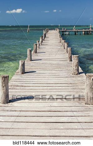 A long wooden jetty or pier, stretching out over the water at Cancun View Large Photo Image Picture - A long wooden jetty or pier, stretching out over the water at Cancun. Fotosearch