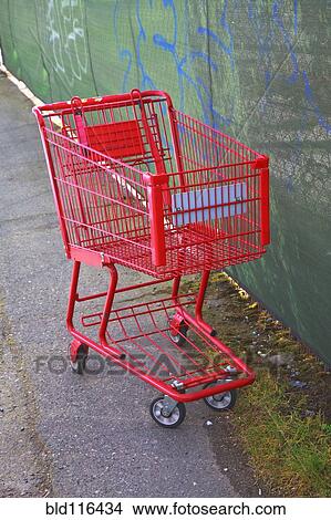 A red metal shopping cart or trolley on a sidewalk View Large Photo Image Picture - A red metal shopping cart or trolley on a sidewalk. Fotosearch