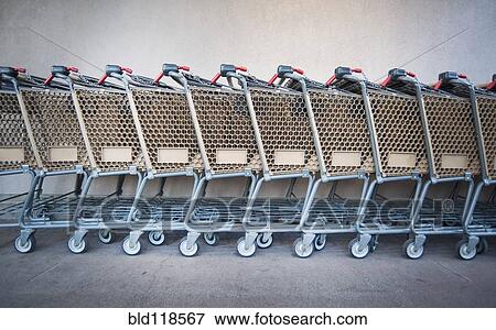 A row of grocery carts stacked together in a line outside a store View Large Photo Image Stock Photo - A row of grocery carts stacked together in a line outside a store. Fotosearch