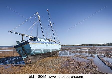 A traditional wooden boat beached at low tide on the sand View Large Photo Image Stock Photography - A traditional wooden boat beached at low tide on the sand. Fotosearch