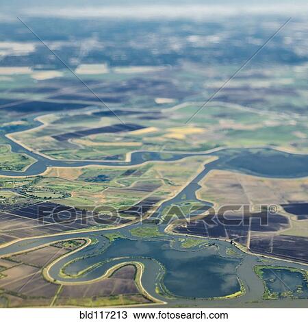 Stock Image - Aerial View of a River Passing Through Farmland. Fotosearch