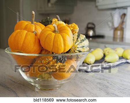 Stock Photo - Bowl of gourds and mini pumpkins on a kitchen counter in a modern fitted kitchen. Fotosearch