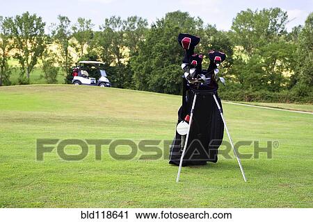 Stock Image - Golf clubs in a bag on the fairway of a golf course. Fotosearch