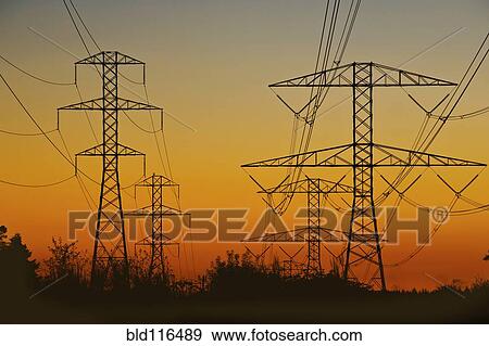 Stock Photo - High Voltage power lines march across open. Fotosearch