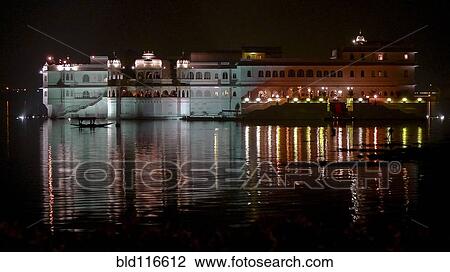Stock Image - Lake Palace at Night With Lights Reflecting in Water. Fotosearch