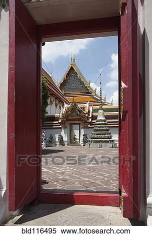 Stock Photography - Large doors frame a view of The Grand Palace or Phra Borom Maha Ratcha Wang . Fotosearch