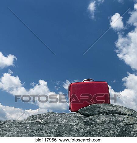 Stock Photograph - Lone Red Suitcase Outdoors. Fotosearch