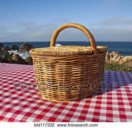 Stock Image - Picnic Basket on Wooden Picnic Table. Fotosearch