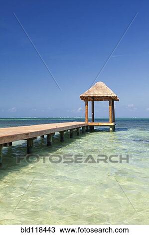 Stock Image - Pier over turquoise blue water on the beach at Cancun. Fotosearch