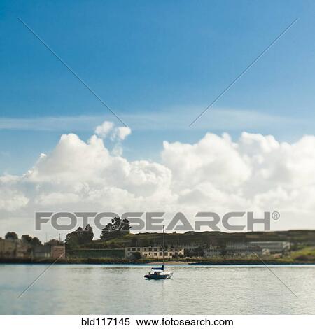 Stock Photography - Small Sailboat Anchored in Bay. Fotosearch