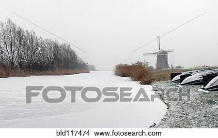 Picture - Snow on the frozen surface of a canal. Fotosearch