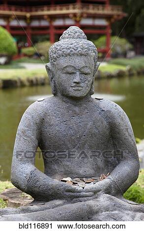 Stock Image - Stone Buddha with Offerings. Fotosearch
