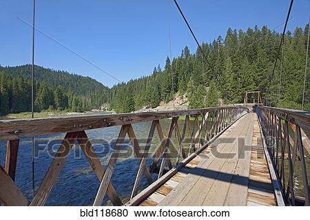 Stock Image - Suspension foot bridge over the Lochsa River. Fotosearch