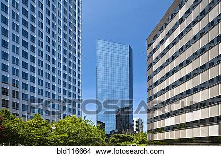 Tall Glass Building Between Two Other Buildings View Large Photo Image Picture - Tall Glass Building Between Two Other Buildings. Fotosearch