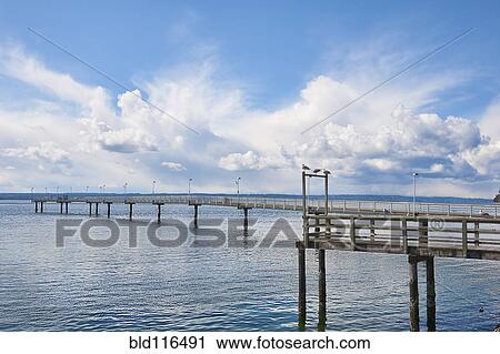 Stock Image - The long fishing pier at Des Moines marina extends far over Puget Sound. Fotosearch