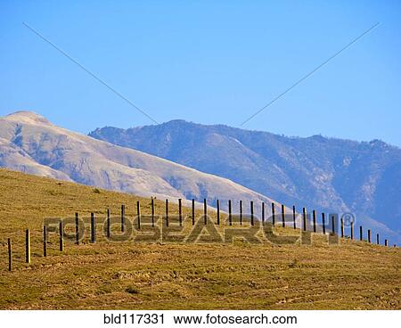 Stock Image - Wire Fence Extending over Hill. Fotosearch