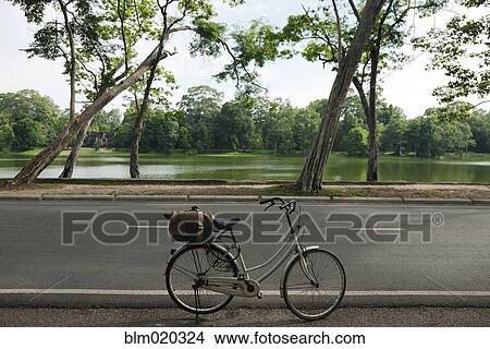 Picture - A bicycle with basket parked on the road to the Angkor Temples. Fotosearch