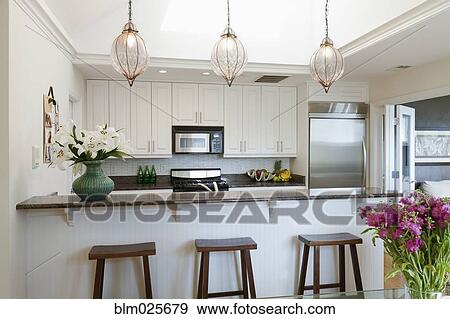 Stock Photo - A contemporary kitchen with a breakfast bar. Fotosearch