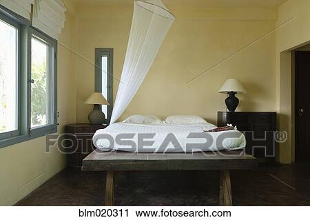 Stock Image - A double bed and mosquito net . Fotosearch