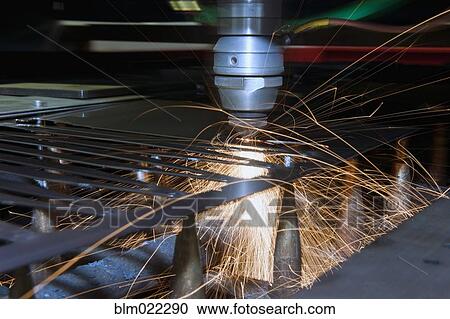 Stock Image - A fully automated laser cutting machine cutting shapes out of a steel sheet. Fotosearch