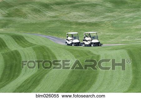 Stock Photography - A golf course with mown fairways creating a pattern on an undulating landscape. Fotosearch