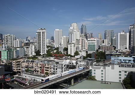 Stock Image - A mass transit train passes through Bangkok downtown business district. Fotosearch