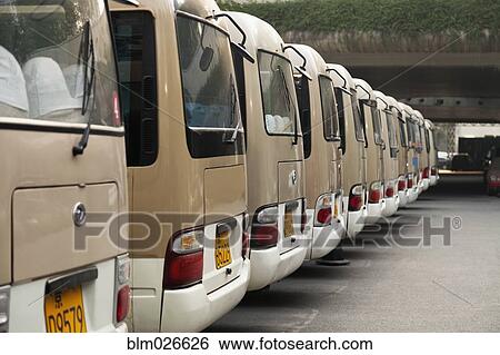 Stock Photograph - A row of large vans or buses lined up in the Central Business District of Beijing. Fotosearch