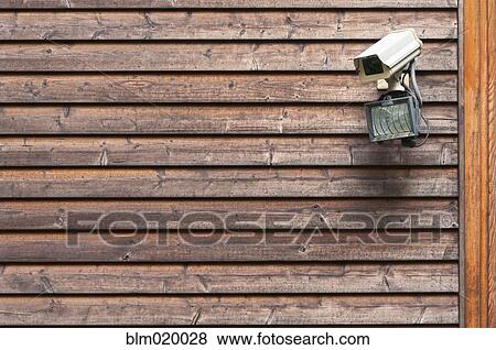 A security camera and light mounted on a building View Large Photo Image Stock Photo - A security camera and light mounted on a building. Fotosearch