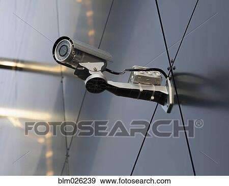 A security camera mounted on the wall of a building View Large Photo Image Stock Photo - A security camera mounted on the wall of a building. Fotosearch