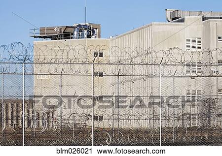 A tall building in a prison complex, with a barbed wire fence at Correctional Facility View Large Photo Image Stock Image - A tall building in a prison complex, with a barbed wire fence at Correctional Facility. Fotosearch