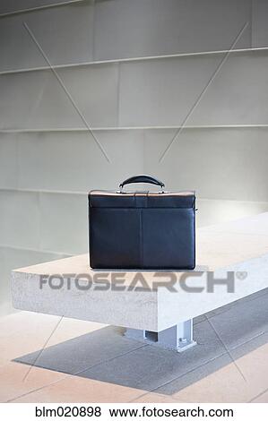 Stock Photo - Black Briefcase on White Stone Bench. Fotosearch