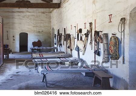 Bunkhouse or sleeping room with cots and riding tack and personal belongings View Large Photo Image Stock Photograph - Bunkhouse or sleeping room with cots and riding tack and personal belongings . Fotosearch
