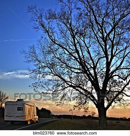 Stock Image - Camper Driving Down a Country Road. Fotosearch
