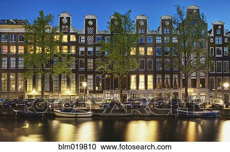 Stock Image - Cars and Canal-front Homes at Night. Fotosearch